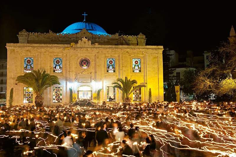 希腊东正教复活节前夜,人们手持白色蜡烛聚集到教堂,由牧师分散点燃
