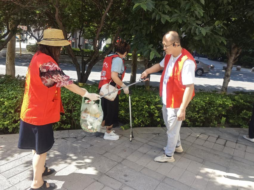 党员和义工队员共同参与,捡拾垃圾清理人行道,为市民,更为过节出游的